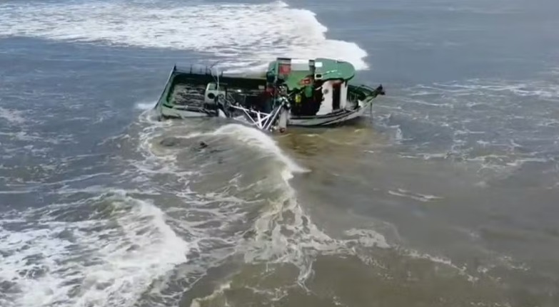 Barco de pesca vira no mar em Imbé 