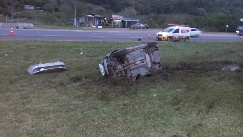 Carro sai da pista, atinge poste e tomba na BR-101, em Osório